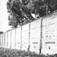 Бывшая стена концлагеря Равенсбрюк, служащая границей мемориального ансамбля. У подножия - братская могила